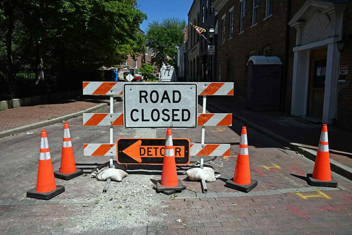 Road closed and detour signs with orange traffic cones