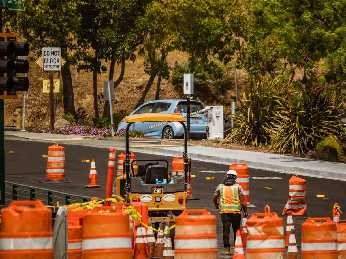 Road worker surrounded by traffic cones on a street